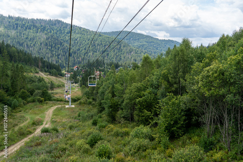 Ski lift in green forest. Cableway in Mountains. Summer nature. photo