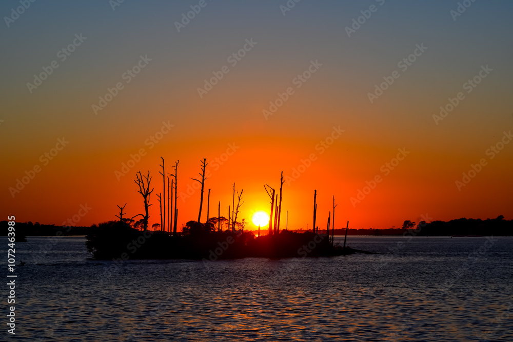 October Orange Sunset over a barrier island by the Intracoastal Waterway in Perdido Key, Florida October Orange Sunset over a barrier island by the Intracoastal Waterway in Perdido Key, Florida