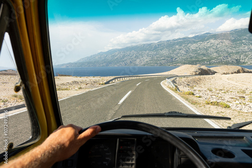 Fotografi Yellow retro camper van parked on the rocky wild terrain on Pag island, Croatia