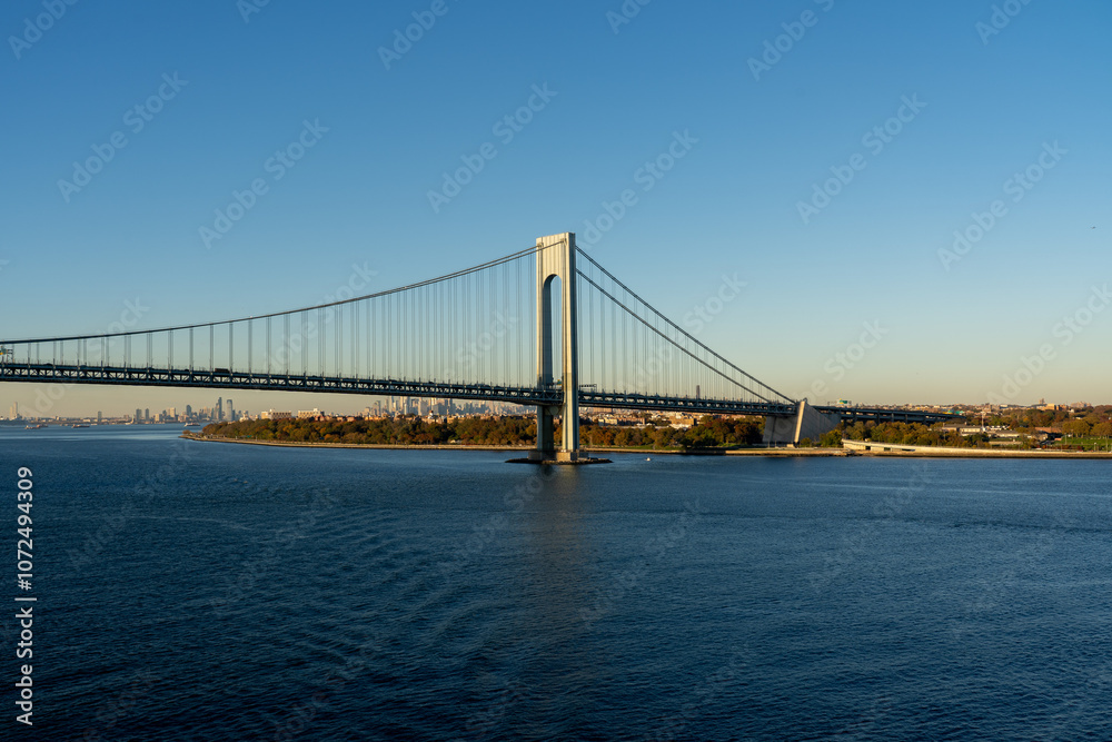 view of Verrazzano-Narrows Bridge over blue water on a sunny day with a clear sky in New York, USA view of Verrazzano-Narrows Bridge over blue water on a sunny day with a clear sky in New York, USA
