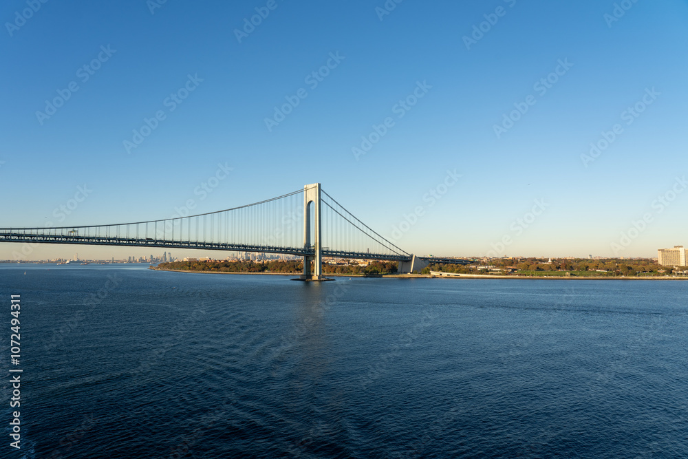view of Verrazzano-Narrows Bridge over blue water on a sunny day with a clear sky in New York, USA view of Verrazzano-Narrows Bridge over blue water on a sunny day with a clear sky in New York, USA