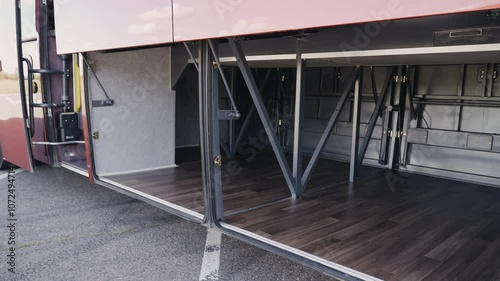 A smooth camera movement reveals the spacious storage compartments beneath a tourist bus. Passengers can comfortably stow their belongings while enjoying the journey.