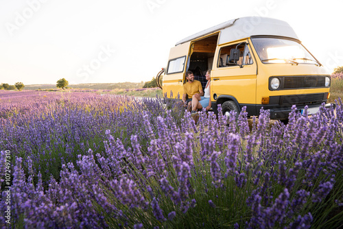 Young happy couple enjoying the view in their retro camper van at sunrise in Valensole lavender fields in Provence, France. Happiness and freedom lifestyle