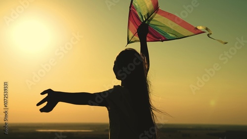 kite. colored rainbow kite hands girl with long hair. happy family. chidhood dream. girl park sunset playing with kite. child teenager journey. fantasy child. concept kite wind. play game nature. sun.