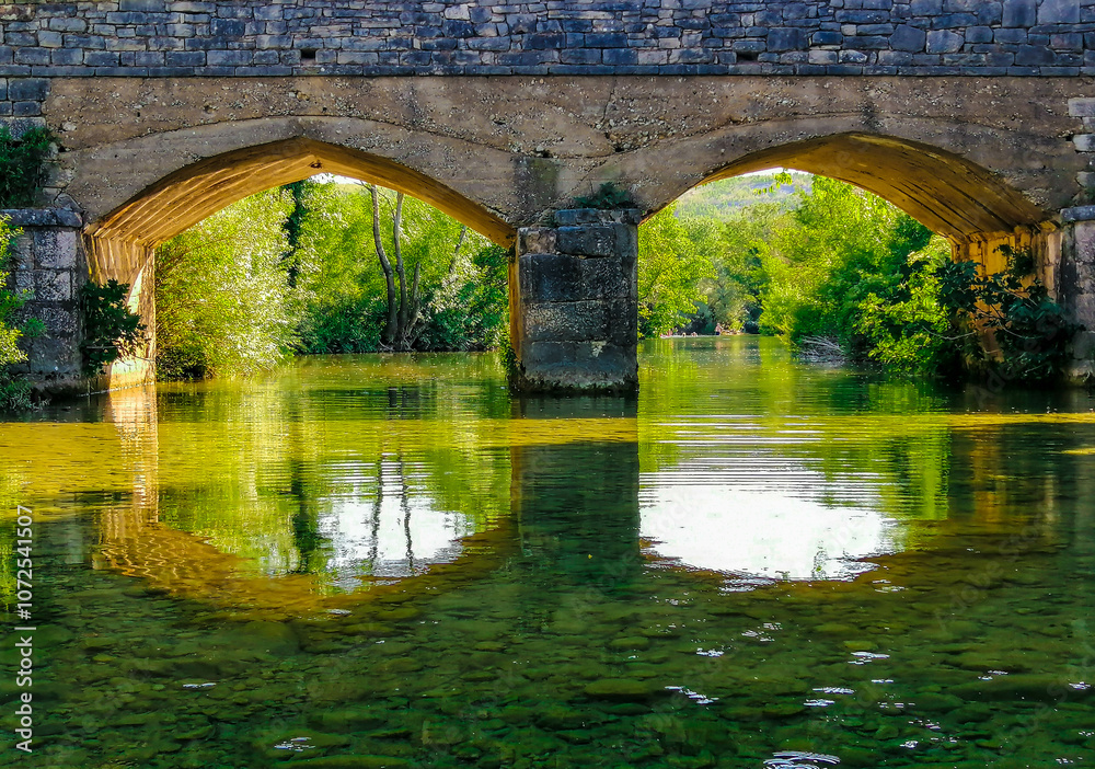 Fototapeta premium Close up of two arches of the bridge that are reflected in the water of the Zrmanja river, Croatia