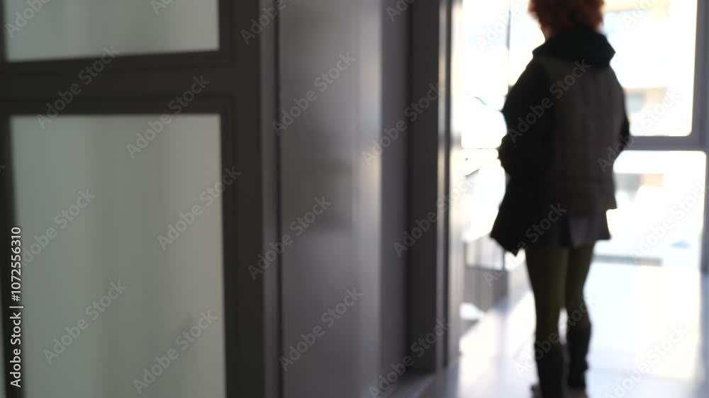blurred silhouette young woman in he hallway of residential building pressing elevator call button blurred silhouette young woman in he hallway of residential building pressing elevator call button