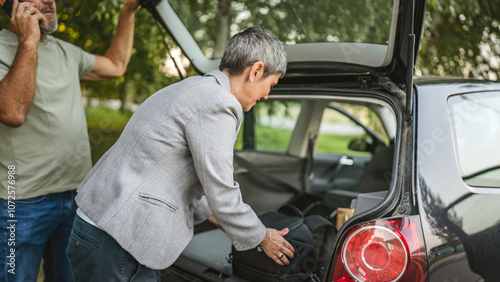 Elderly couple loading car trunk with items before a journey together