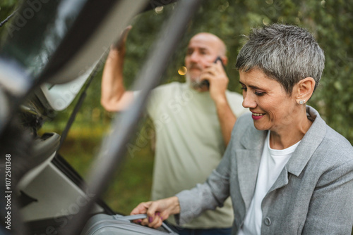 Elderly couple loading car trunk with items before a journey together