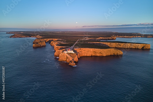 Famous lighthouse Farol do Cabo de Sao Vicente in warm sunset light. Sagres, Portugal