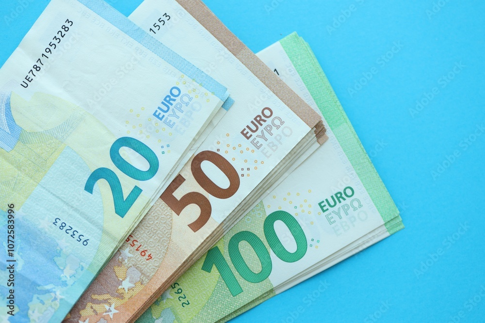 Big amount of one hundred, twenty and fifty euro money bills on blue background Big amount of one hundred, twenty and fifty euro money bills on blue background