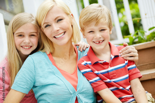 Hug, mother and children portrait outdoor on deck by stairs with smile and summer fun on holiday. Garden, together and home patio with love, care and support with sun and youth on family vacation photo