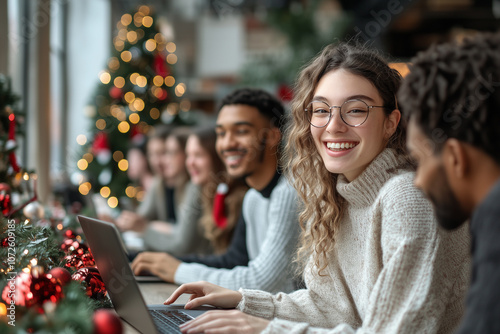 A group of people are sitting around a table with a laptop open