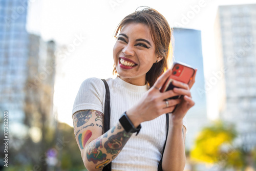 Happy young woman using mobile phone in the city
