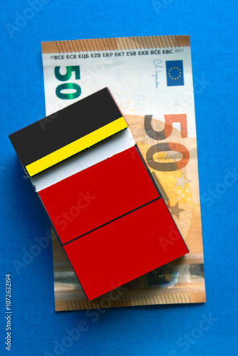  packet of cigarettes on 50 euro money banknote, on blue background. top view