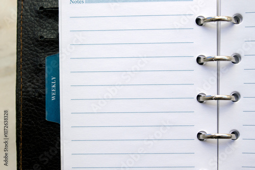 close up  of an open daily brown calendar with silver rings isolated on white background. selective focus