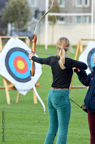 A young woman learnis the basics of archery
