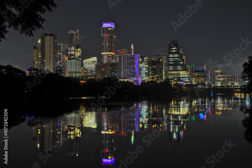 Austin Texas skyline at night, with the lights reflecting in Lady Bird Lake - Colorado River.