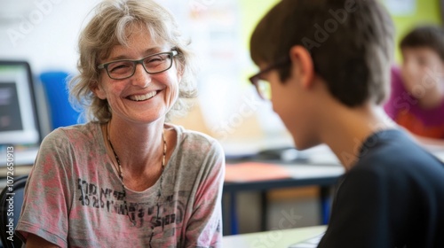 Professor smiling as she supports young student in classroom e-learning session