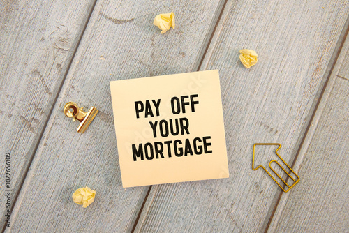 Closeup on businessman holding a card with PAY OFF YOUR MORTGAGE message photo