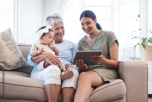 Granny, mother and baby on sofa, tablet and relax with happiness, bonding together and smile. Family, generations and mama with kid, technology and house with infant, online video and digital app photo