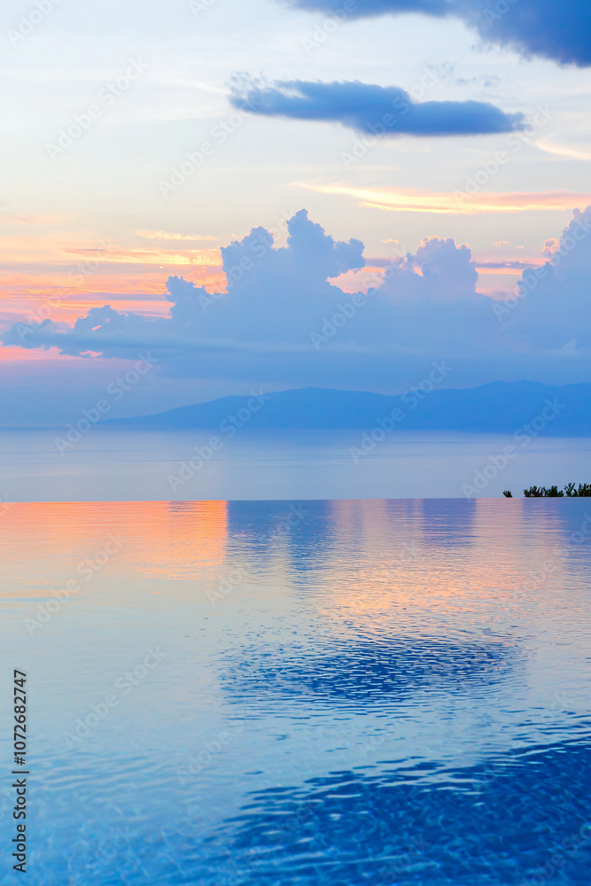 Fototapeta premium a contemporary seaside villa with infinity pool reflecting sunset