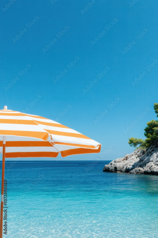 Fototapeta premium Orange umbrella on the tropical beach for vertical background