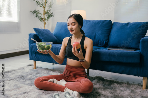 Cuadro en lienzo Sitting on a rug in her living room, a young woman in sportswear contemplates he