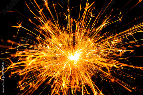 Sparkler background. New year sparkler on black background. Christmas sparkler backdrop. Fiery sparks backgrounds. Background for copy space. Firework effect. Bright sparkles background.