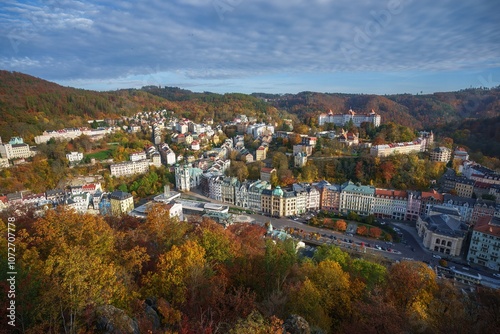 Karlovy Vary city aerial panoramic view in with row of colorful multicolored buildings and spa hotels in historical city centre. Panorama of Karlsbad town and Slavkov Forest mountains in autumn.