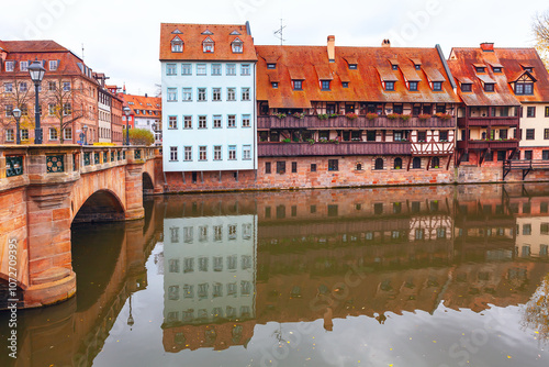 Obraz na płótnie Maxbrucke bridge over Pegnitz river in Nuremberg. Scenic view of a bridge crossing a river, framed by residential coastal buildings w salonie