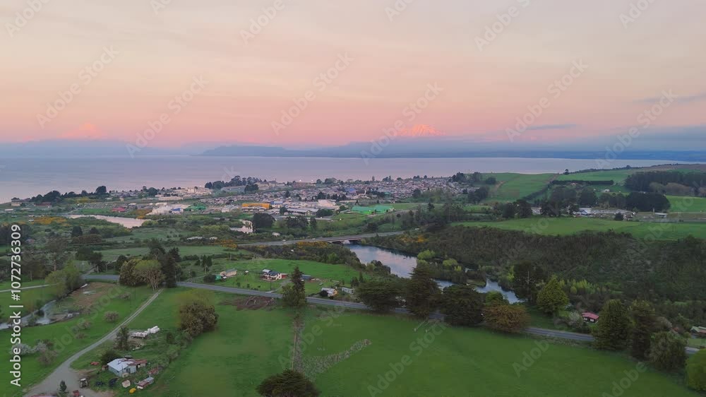 Aerial view of Llanquihue city with Osorno and Calbuco volcanoes and Llanquihue lake on sunset Aerial view of Llanquihue city with Osorno and Calbuco volcanoes and Llanquihue lake on sunset