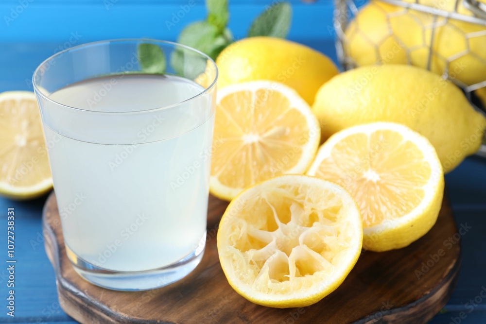 Fresh juice in glass and lemons on table, closeup Fresh juice in glass and lemons on table, closeup