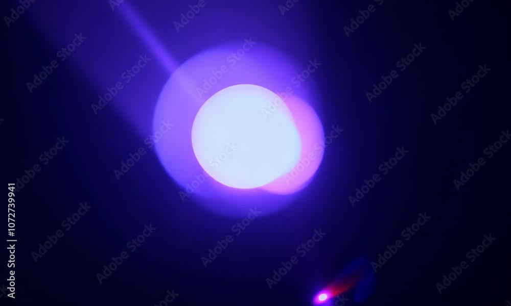 Blue round light flickers, fades to black and changes it's color into the violet. Lense flare is moving and makes a transition of color