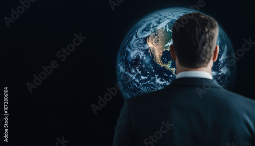 A man in a suit gazes thoughtfully at a vivid depiction of Earth, symbolizing global awareness and contemplation of humanity's future.