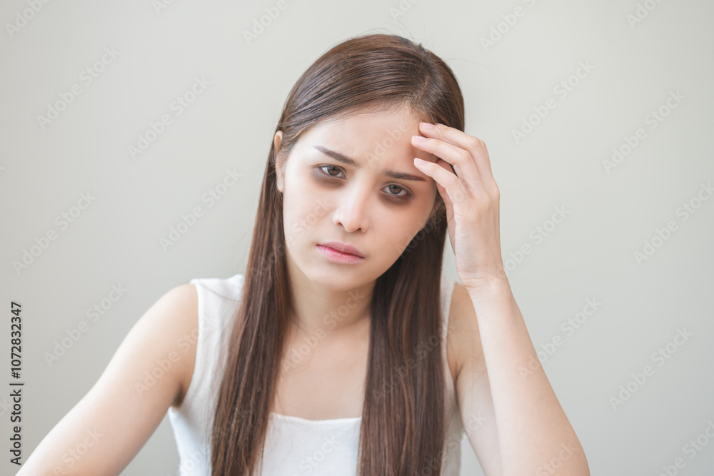 Bored, insomnia asian young woman, girl looking at camera, hand touching under eyes with problem of black circles or panda puffy, swollen and wrinkle on face. Sleepless, sleepy healthcare person. Bored, insomnia asian young woman, girl looking at camera, hand touching under eyes with problem of black circles or panda puffy, swollen and wrinkle on face. Sleepless, sleepy healthcare person.