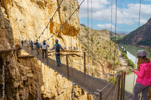 Bild auf Leinwand People crossing the suspension bridge of the Caminito del Rey
