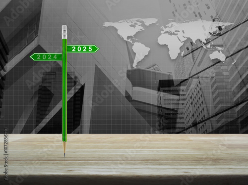 Fototapeta Naklejka Na Ścianę i Meble -  2025 and 2024 direction sign plate with green pencil on wooden table over world map, city tower and skyscraper, Business happy new year 2025 planning concept, Elements of this image furnished by NASA