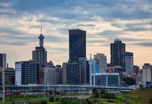 Johannesburg cityscape with Nelson Mandela bridge going over the railway, Hillbrow telecommunications Tower in city skyline downtown buildings South Africa at down dusk late evening photo