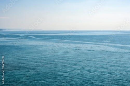 Vast open water with a subtle gradient of blues, wave patterns, serene ambiance, expansive horizons, underwater world, aquatic life