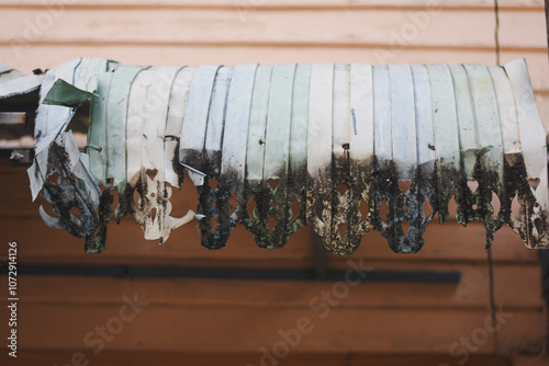 deteriorated and partially torn awning or canopy. The material appears to be fabric or plastic, and it is heavily weathered and discolored.