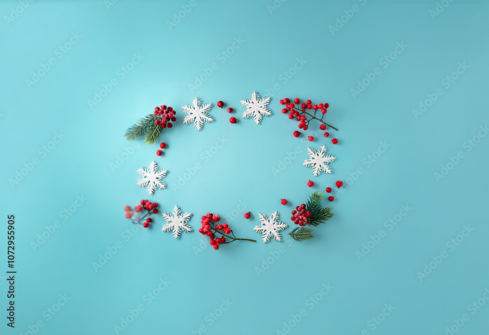 A festive wreath of white snowflakes, red berries, and evergreen sprigs on a light blue background. A festive wreath of white snowflakes, red berries, and evergreen sprigs on a light blue background.