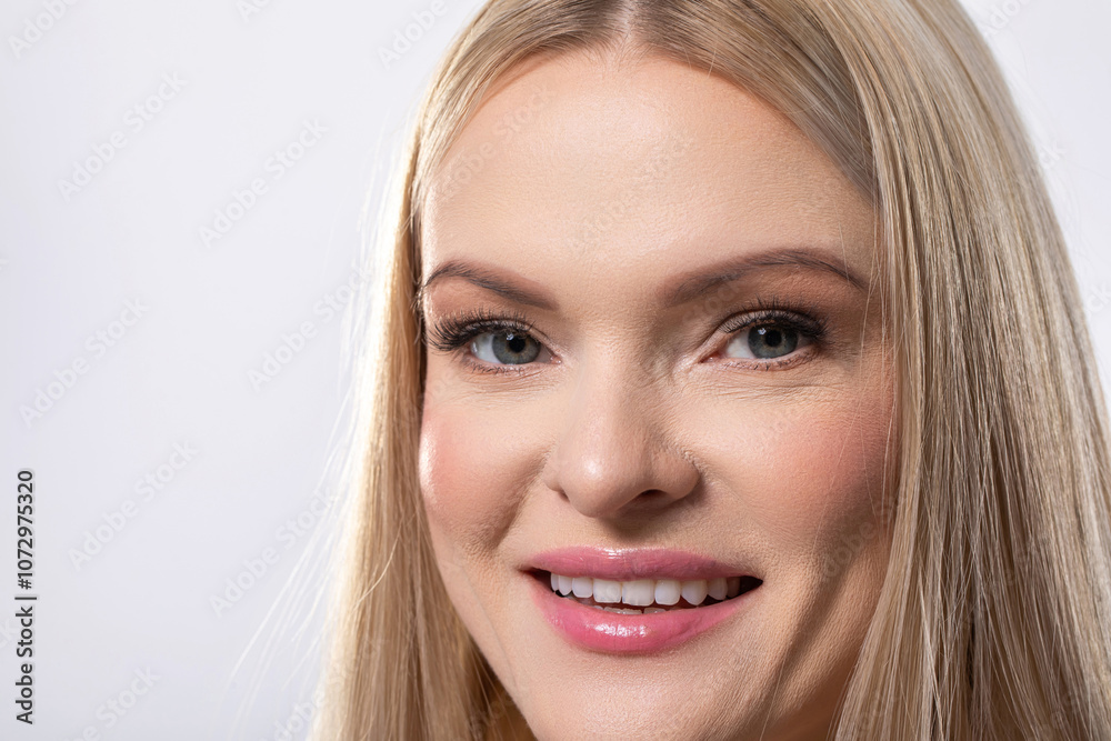 A Smiling Woman with Long Blonde Hair Posing Beautifully in a Bright Studio Setting A Smiling Woman with Long Blonde Hair Posing Beautifully in a Bright Studio Setting