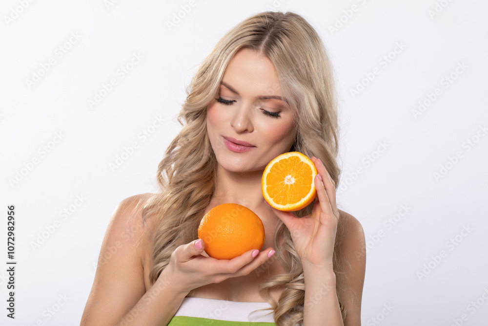 A Woman is Cheerfully Holding an Orange Alongside a Halved Orange, Radiating Happiness A Woman is Cheerfully Holding an Orange Alongside a Halved Orange, Radiating Happiness