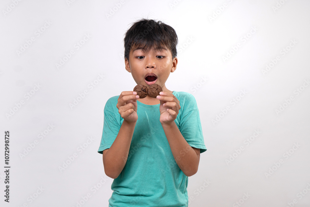 young boy hanging tasty cookies on white background young boy hanging tasty cookies on white background