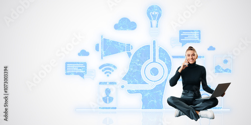 Woman sitting cross-legged with laptop and phone, surrounded by digital techn...
