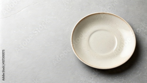 A plain white saucer sits alone on a textured gray surface, waiting to be filled with something special.