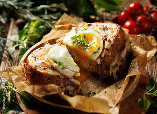 Hot croque madame sandwich cut in half, showing the yolk leaking out. A traditional French sandwich