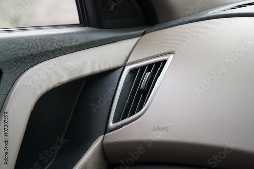 Car interior with view of air conditioner vent and side view mirror. ac vent for air flow in passenger side.