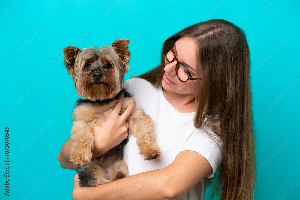 Young Lithuanian woman holding a dog isolated on blue background Young Lithuanian woman holding a dog isolated on blue background