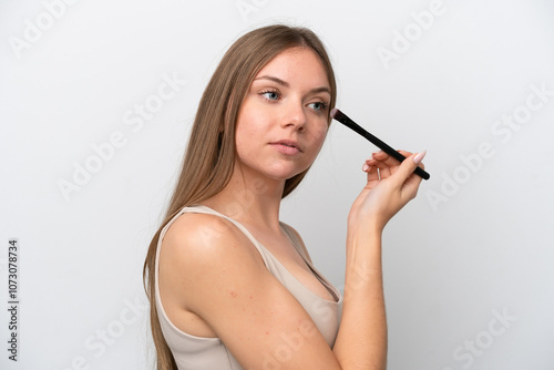 Young Lithuanian woman isolated on white background holding makeup brush